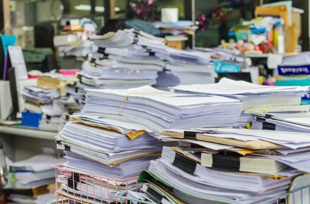 36525737 – pile of documents on desk stack up high waiting to be managed.
